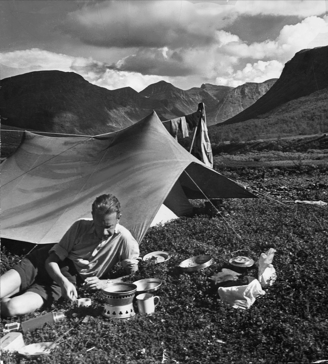 Dag Hammarskjöld kokar kaffe utanför sitt tält i Sarekfjällen. 