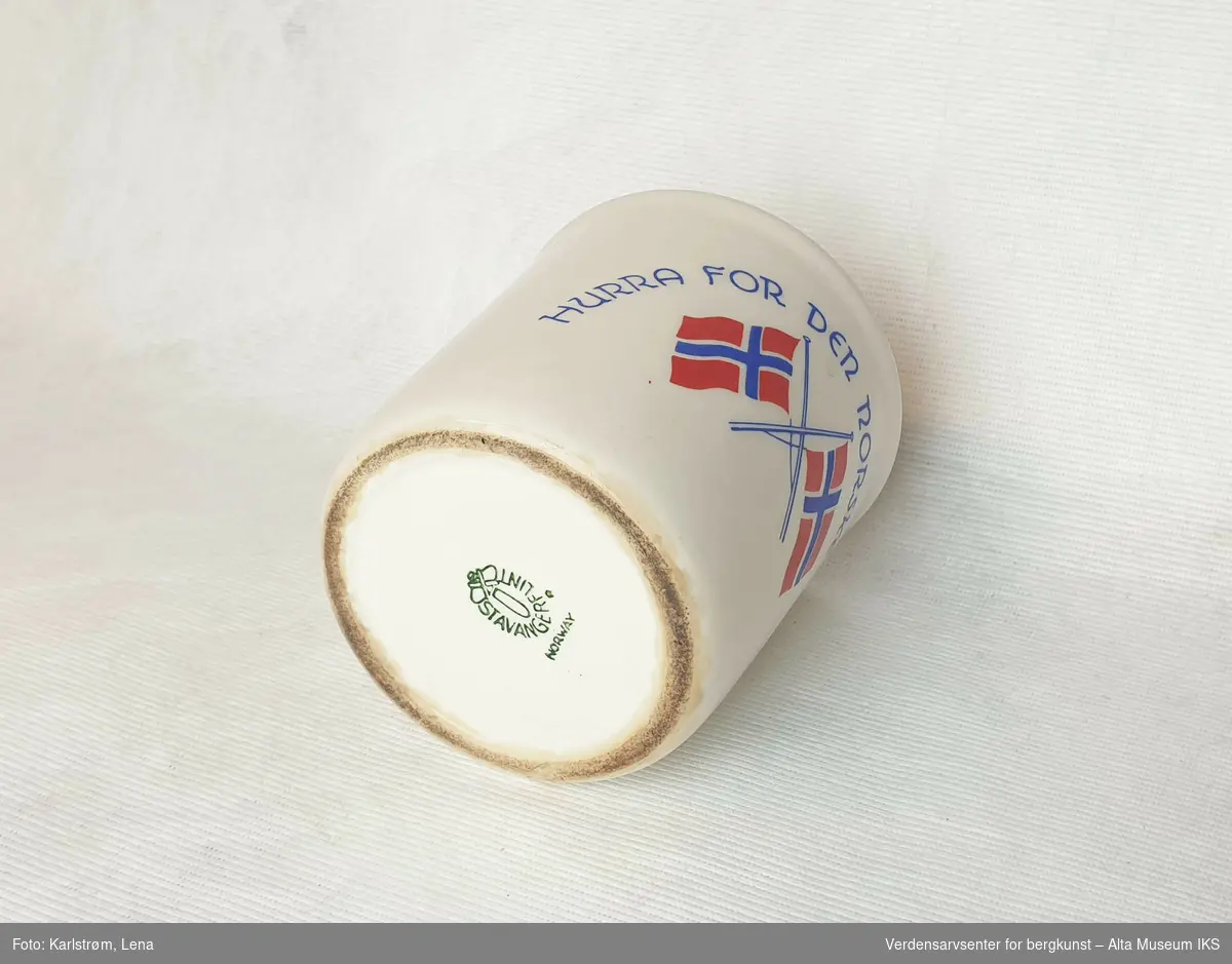 Kopp i hvitt porselen dekorert med gullkant, to norske flagg og teksten "Hurra for den norske fisker"