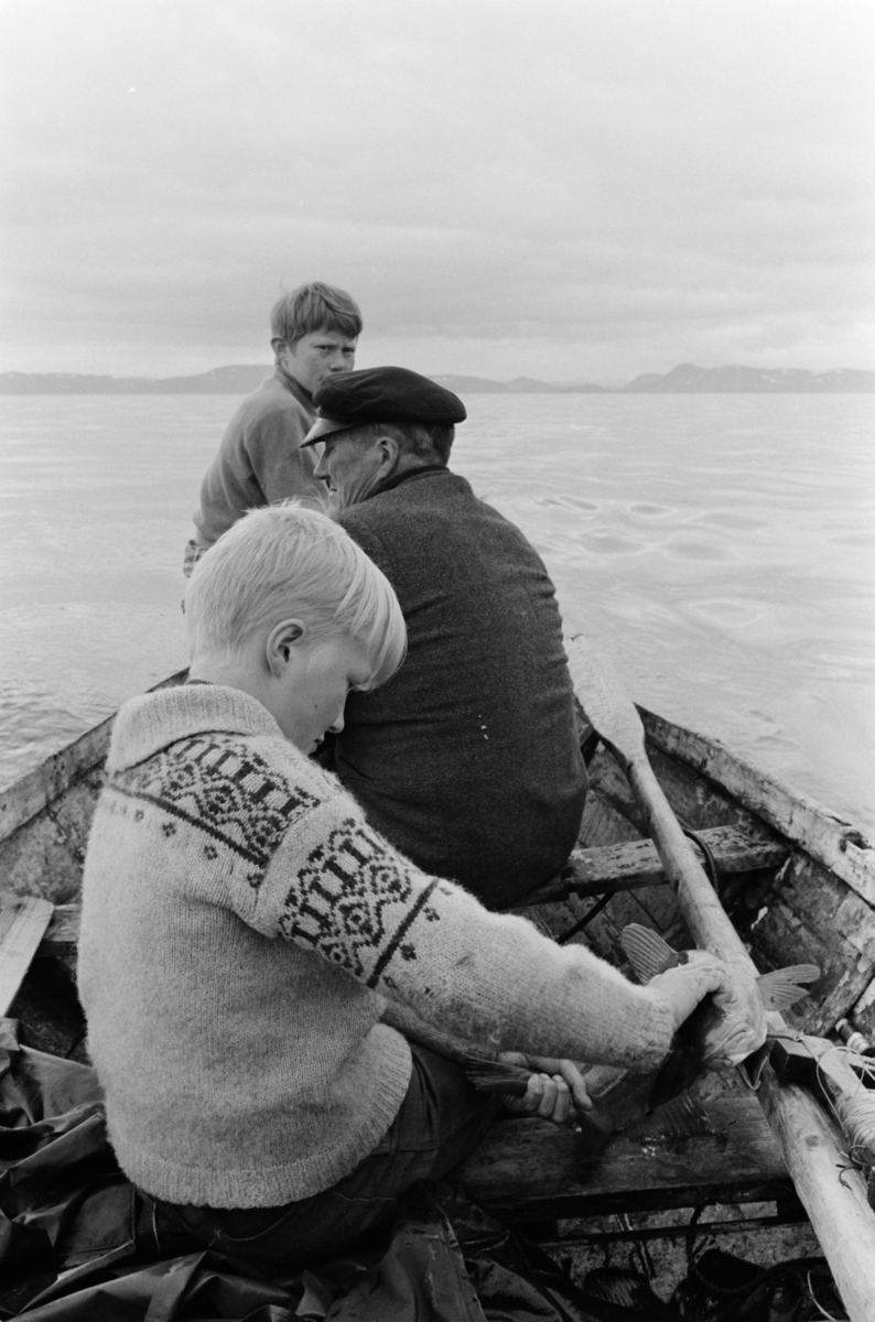 Gutter og eldre mann i båt.