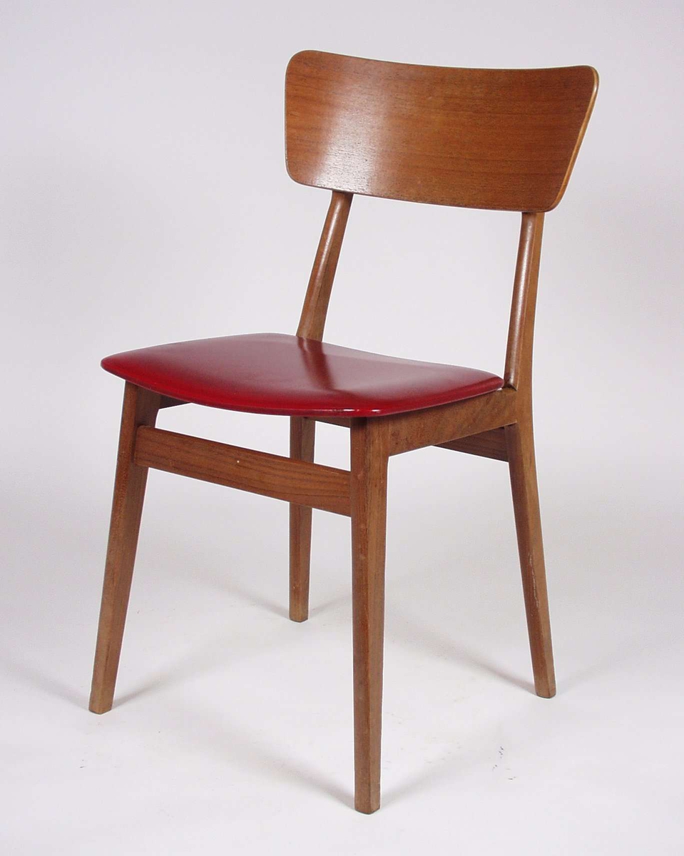 Stolen er av tre med formpresset sete og rygg. Setet er trukket med rødt imitert skinn over skumgummi.