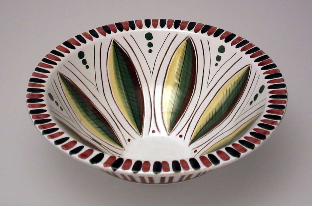Keramikkbolle med lys glasur. Dekoren er risset inn i godset og malt.