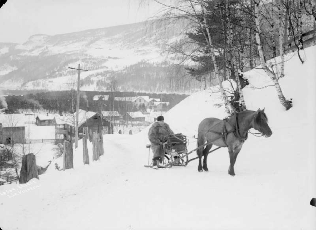 04.03.1908. Ringebu. Lensmann Dahl med hest og slede. Bebyggelse, bjørketrær, vei, åsside.