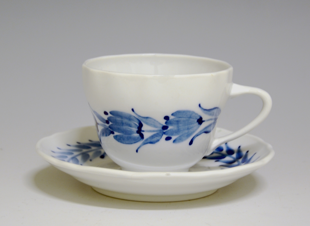 Kaffeskål av porselen. Hvit glasur. Håndmalt blå underglasurdekor på fanen.
Modell: Victoria, 1800
Uten fabrikkmerke.