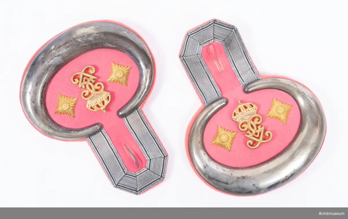 Grupp C I.
Epåletter med rosa klädesmatta och en silverplåt. På epåletthalsen en silvergalon, b:10 mm. Fodrade med rosa kläde. På epåletternas nedre del finns svenske konungens namnchiffer kung Gustav V.