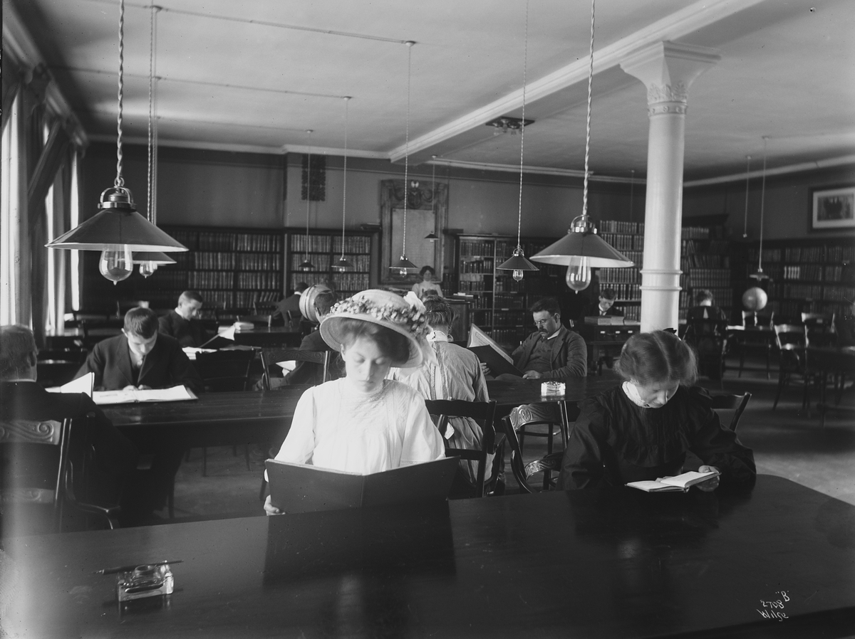 Bibliotekets lesesal, yngre kvinner og menn, antatt studenter, i dyp konsaentrasjon.