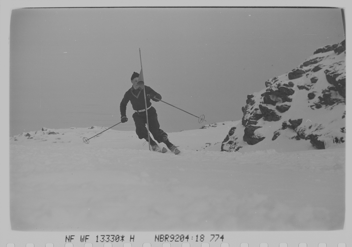 Mann på ski i slalåmbakke. Fotografert 1940.