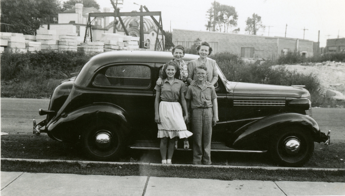 Personer foran gammel bil i USA. Chevrolet 1938. Bak fra venstre Anne Breidokk, framme til høyre hennes sønn Kennet