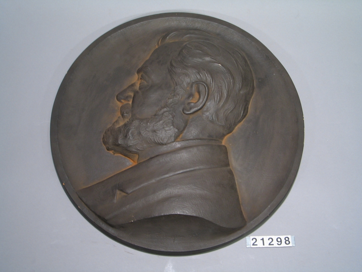 Porträttmedaljong i gips över Lars Magnus Ericsson, f. 1846, d. 1926. Utförd efter medaljong i brons.