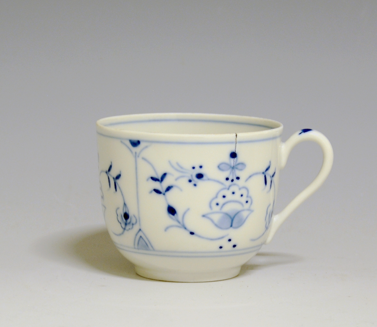 Kaffeskål i porselen. Dekorert med håndmalt stråmønster i blått. 

Dekor: "Porsgrunnsmønsteret", variant av stråmønster, antagelig av Hans Flygenring.