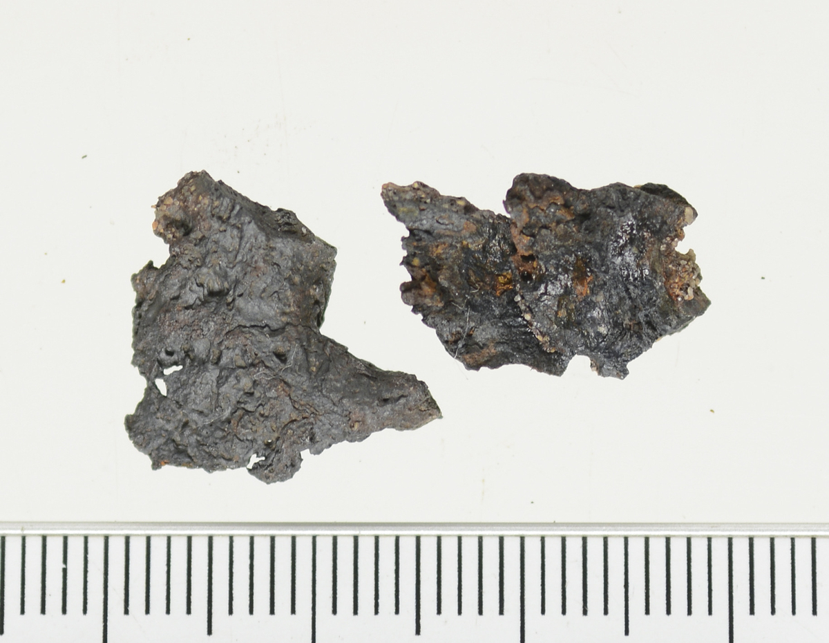 Ett fragment av jern funnet i lag 2 i S10214, en avfallsgrop i det som er tolket som et smieområdet. Kan være en nagle ut i fra form på røntgen. Antydning til et hodet, og en liten del av en bevart stilk.  Funnet er konservert.