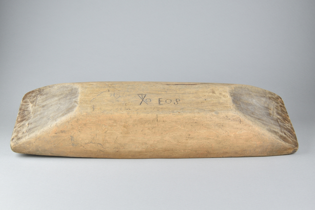 Tråg tillverkad i trä. Utförd i ett stycke. Rektangulär och djup. Undersidan med inskriften "EOS" samt åtalet "1786".