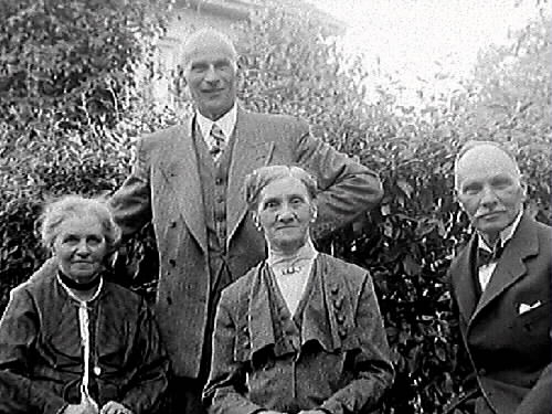 Fyra personer i fotograf Mathilda Ranchs trädgård i kv Bagaren, från vänster: Mathilda Ranch, hennes bröder stenhuggeriägare Erik Ranch och köpman Wilhelm Ranch samt Maria Bäckström.
