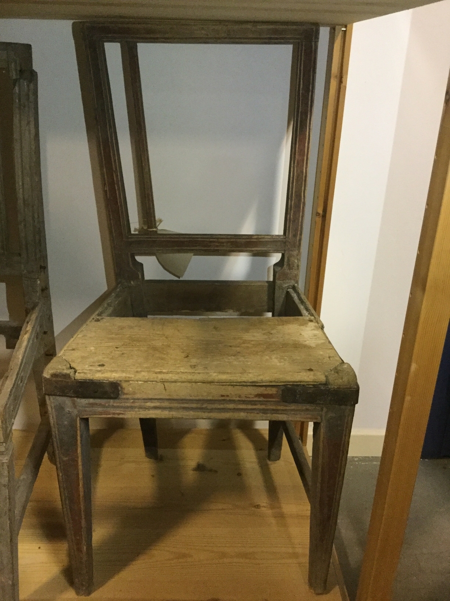 Rödmålad stol rygg med 5 st spjälor varav 4 saknas, stolen har färstärkts med spikade järnband runt framsargens främre hörn, delar av krysset saknas, för övrigt likadan som inventarienummer 16038 och 22446.