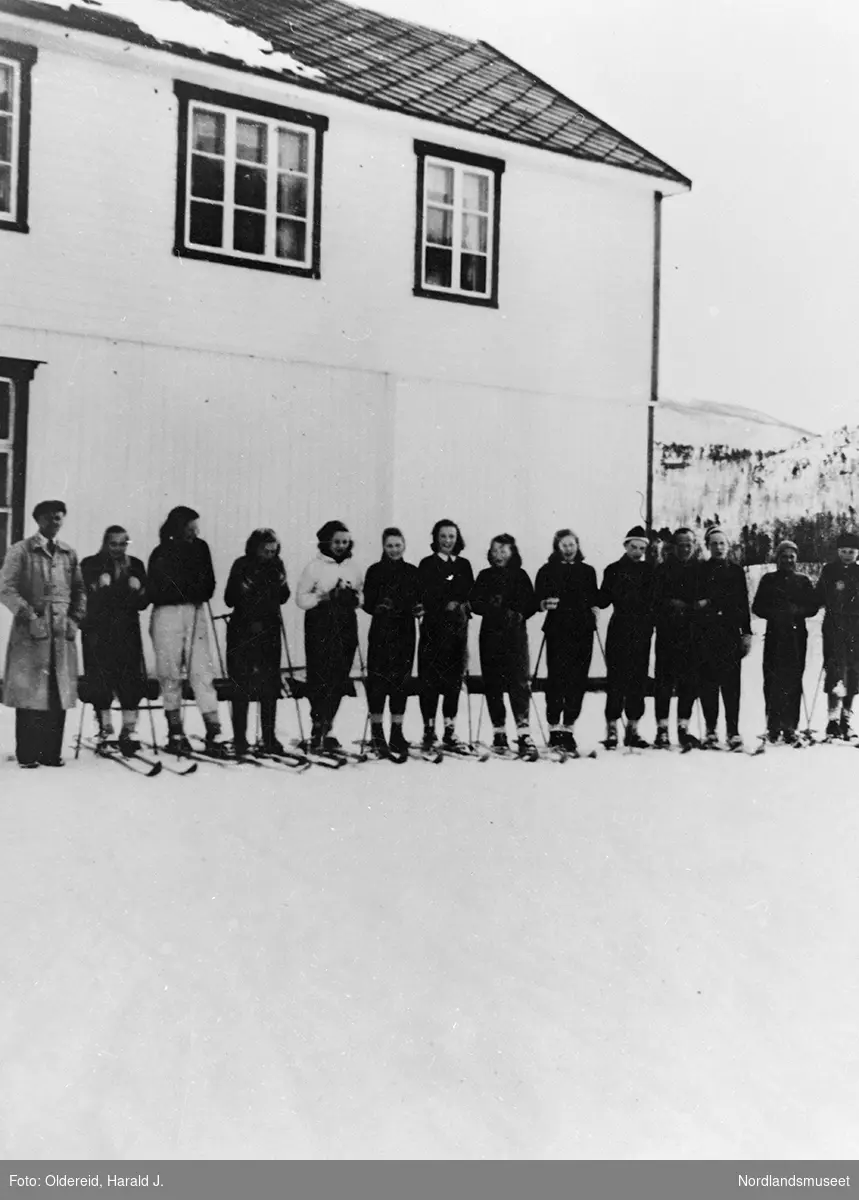 Elever på ski oppstilt foran Oldereid skole. Lærer Kjell Slungård helt til venstre.