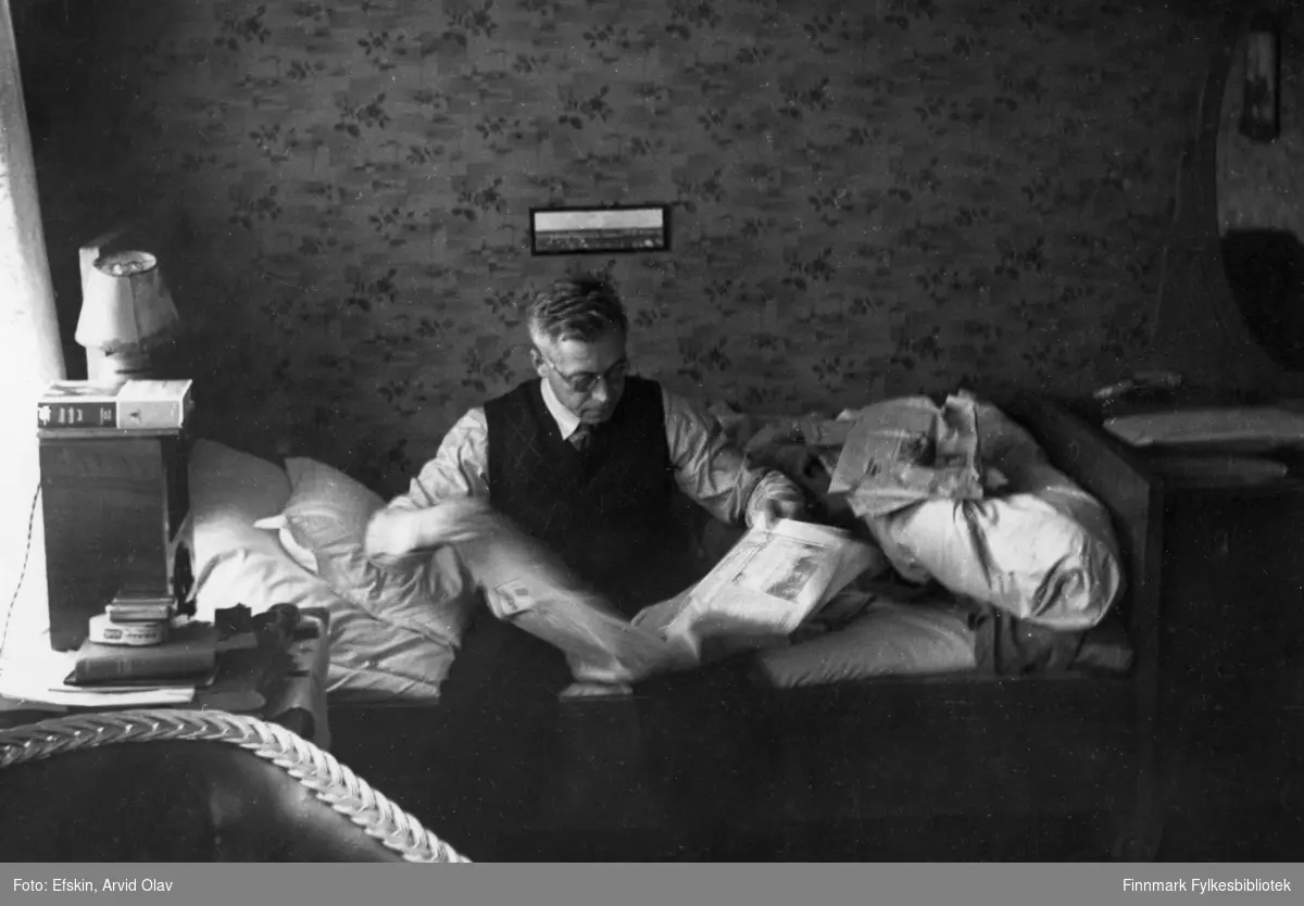 Tormod Berg sitter på sengen og leser "Steinkjærnytt", Vadsø i 1939.