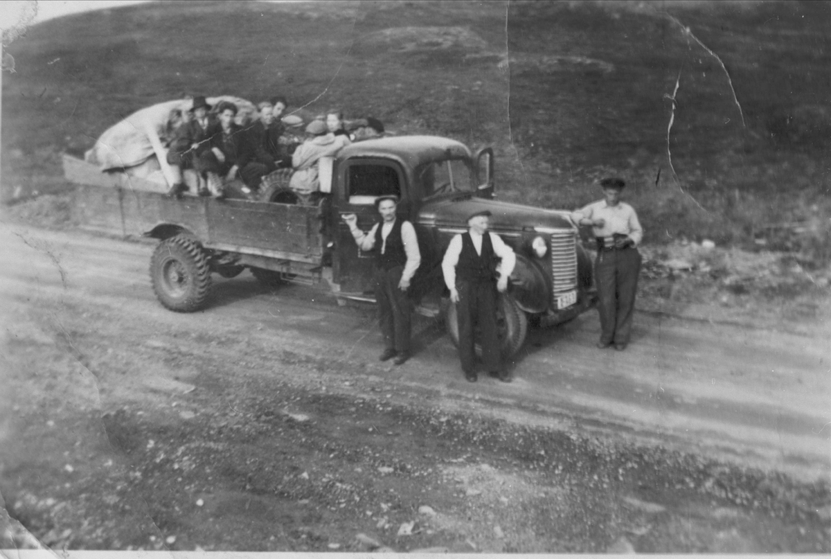Veiarbeidere med lastebil i Trøsemarka. Noen sitter i lasteplanet, tre menn står foran.