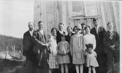 Gruppebilde av familie, samlet foran et hus i Bjørndalen på 