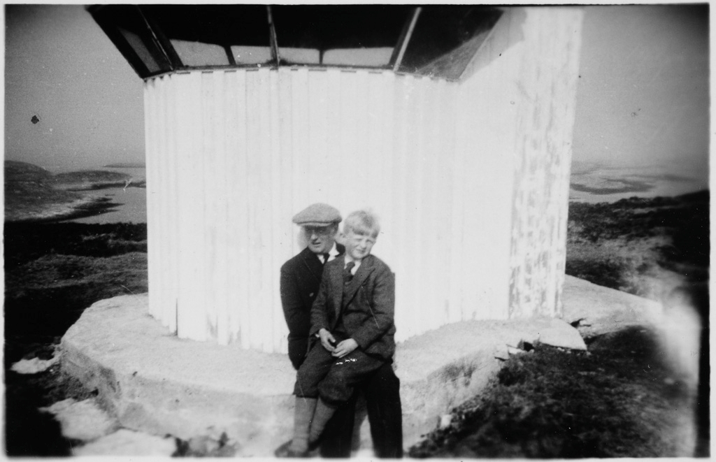 Bilde av en mann med gutt på fanget "Fra Laûgen i Aasver 1935"