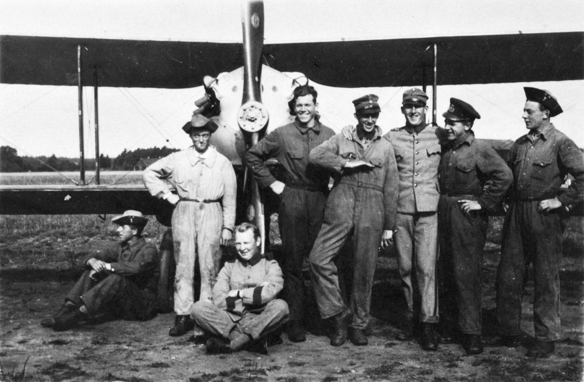Grupporträtt av militärer framför flygplan J 2, Nieuport ND 29C1, omkring 1930. Åtta män framför flygplanets nos.