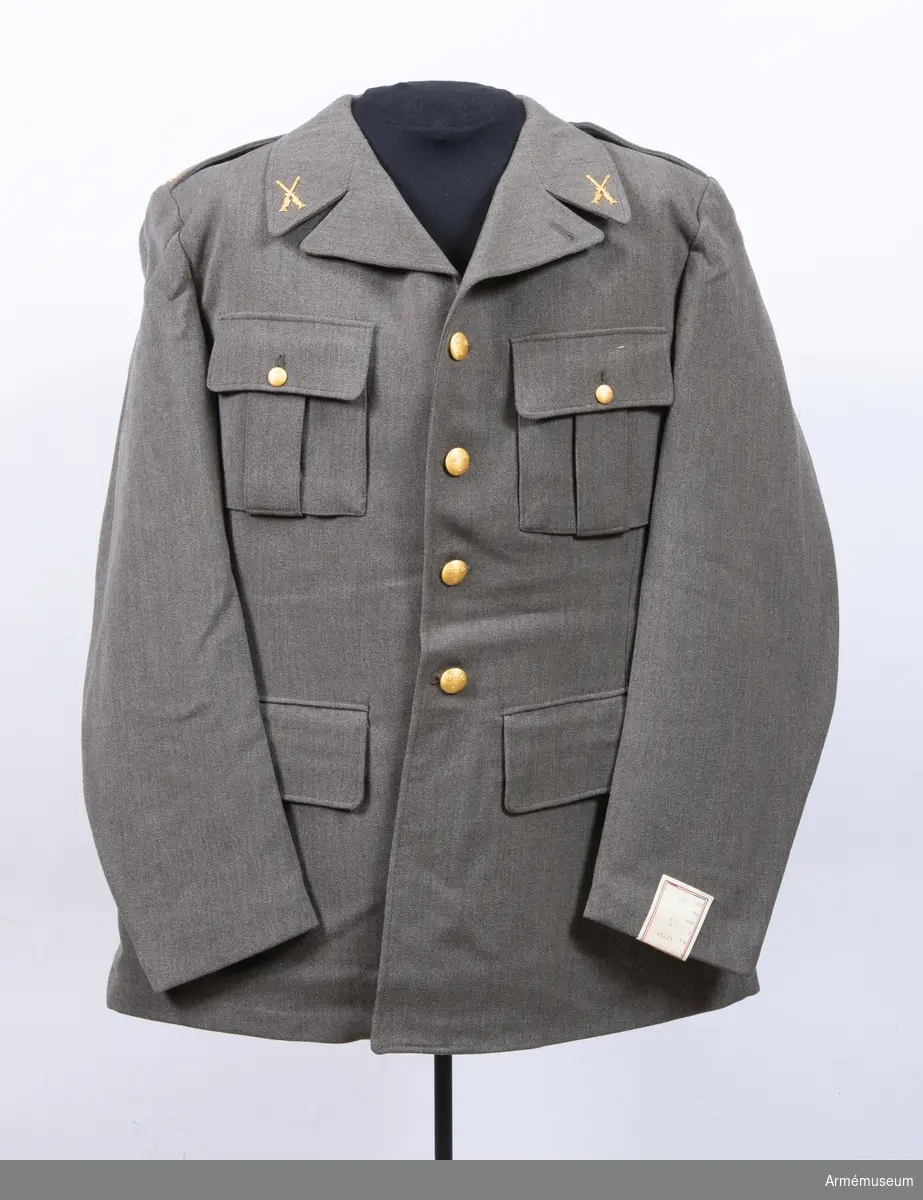 Stl 96 II. Av samma snitt som uniform m/1939. Daglig dräkt av gråbrungrönt  tyg och bärs till mörkt gråbrungröna byxor. Tjänstetecken mattförgyllda.