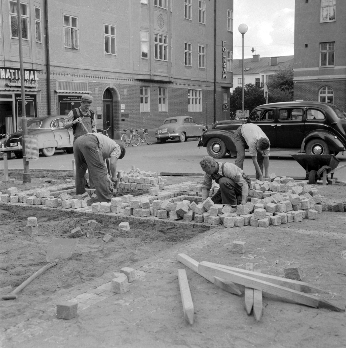 Styvt arbete och krökta ryggar. Hospitalstorget i Linköping får ny stenbeläggning 1953.