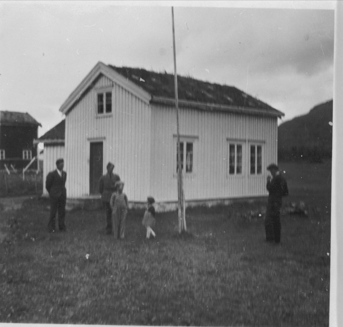 Tre voksne og to barn foran gården til Joakim B. Antonsen på Myklevoll.