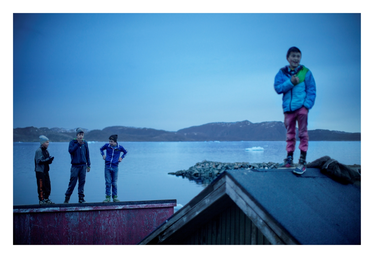 Barn henger rundt fiskeplassen i Narsaq sent på kvelden. Det australske gruveselskapet Greenland Minerals and Energy (GME) ivrer etter å få de nødvendige tillatelser til å starte utvinning ved byen og har lovet de 1500 som fortsatt bor i Narsaq at det blir arbeidsplasser og liv i byen. Det siste året har 600 mennesker forlatt Narsaq, i håp om ny jobb og et bedre liv. Arbeidsledigheten er offisielt på 15 prosent.