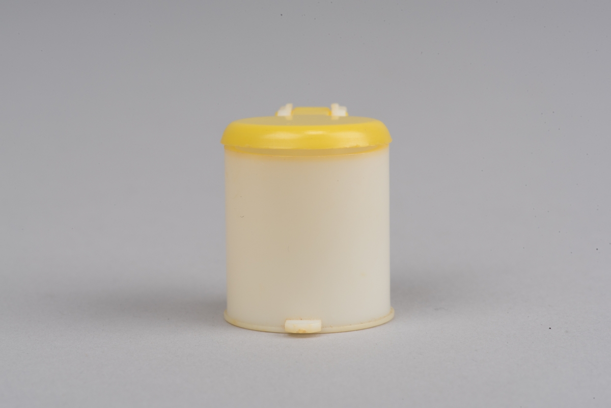 Dokskåpsinredning i form av en pedalhink av plast. Locket går att öppna.
Cylinderformad hink i vit plast med pedal och öppningsbart gult lock.