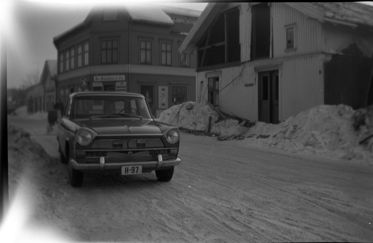 Bil i bymiljø og riving av bygning, bil registrert H.97, en Fiat 1900, 1959-68.

Fotosamling etter fotograf og kringkastingsmann Rikard W. Larsson (31.12.1924 - 08.06.2015).