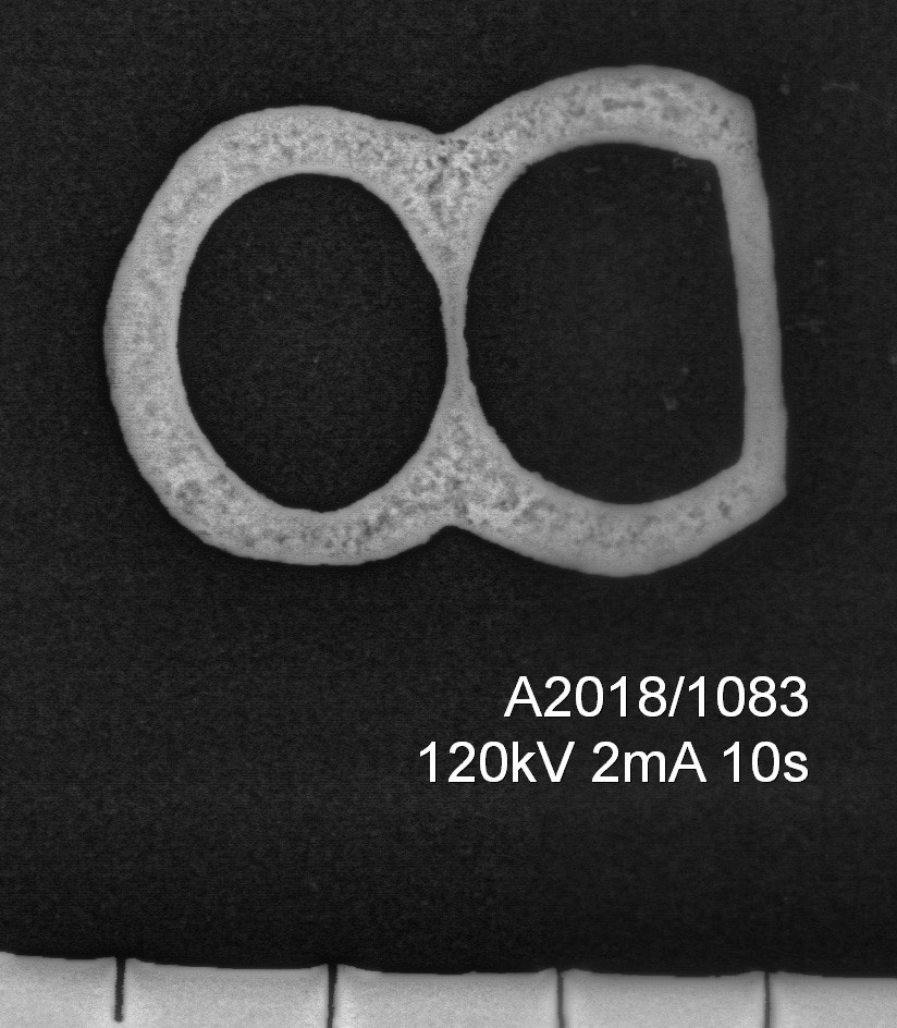 Remspenne av kobberlegering nærmest lik Egan og Pritchard 2002: fig. 333, men med en asymmetrisk dobbelramme. Overflaten er svært korrodert. L.: 3,0 cm, b.: 2,2 cm, h.: 0,6 cm. Vekt: 3,7 g.