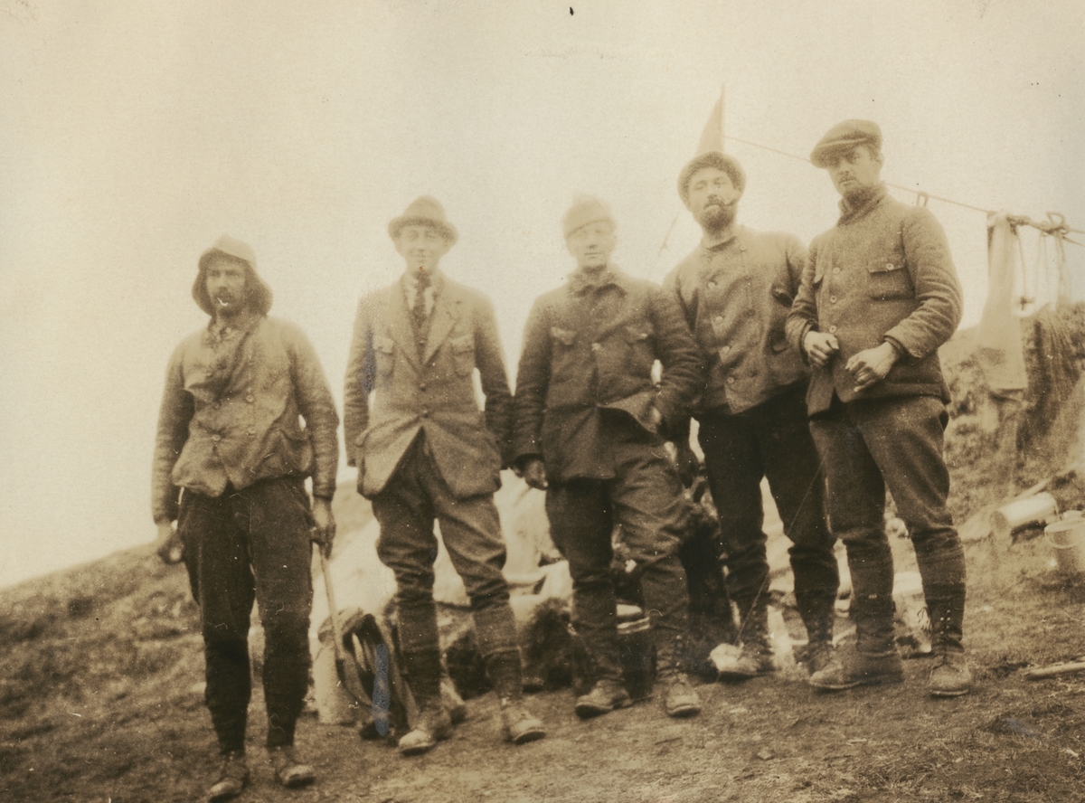 Fotografi från expedition till Sveagruvan. Motiv av fem expeditionsdeltagare som poserar vid lägerplats.