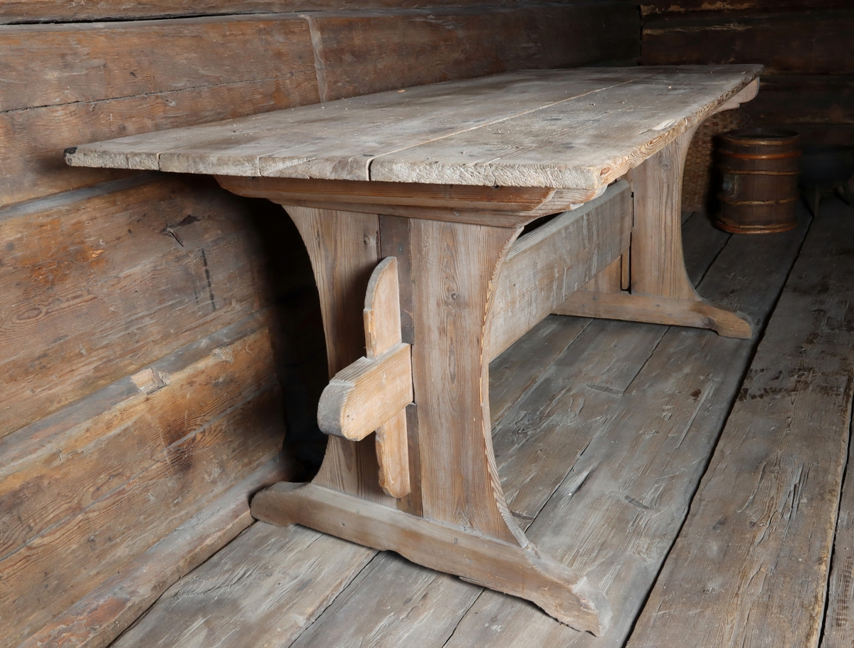 Bord tillverkad i furu, med rektangulär bordskiva. Skivan vilar på två breda ben, sammanhållna i mitten av en stabiliserande slå.
Bordet har en skuren märkning "I.N.T. 1790" på tvärslån mellan bordets ben.