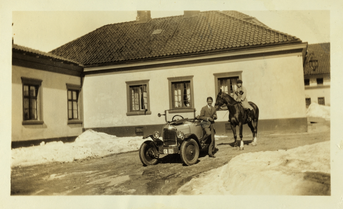 Ung mann, antagelig Per Mørch Hansson, ved bil og Karen Egeberg på hesten "Fox" på gårdsplassen på Bogstad gård. Antagelig fotografert våren
1926. 