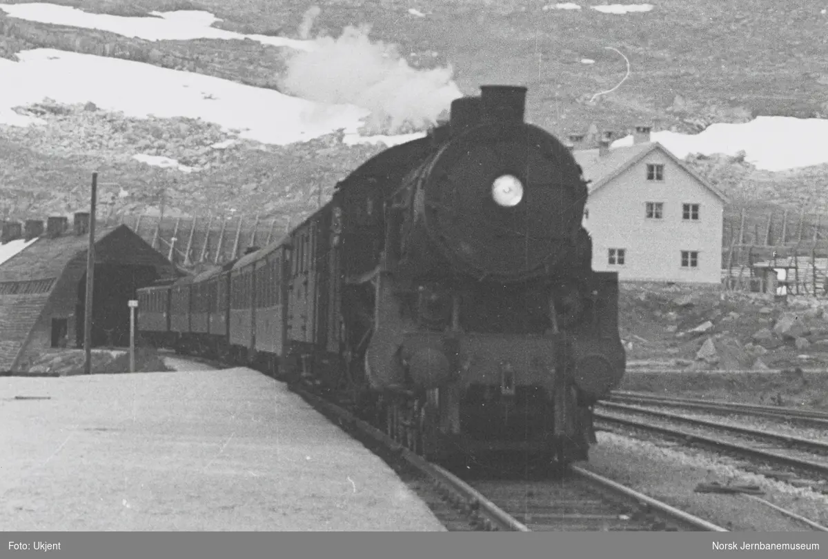 Damplokomotiv type 31b med dagtoget fra Bergen til Oslo Ø, tog 602, kjører inn på Finse stasjon
