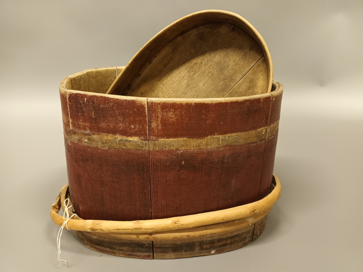 Raudmåla lagga holk med sveipt lok. Oval form. To tregjorder. Den eine av gjordene er øydelagt,