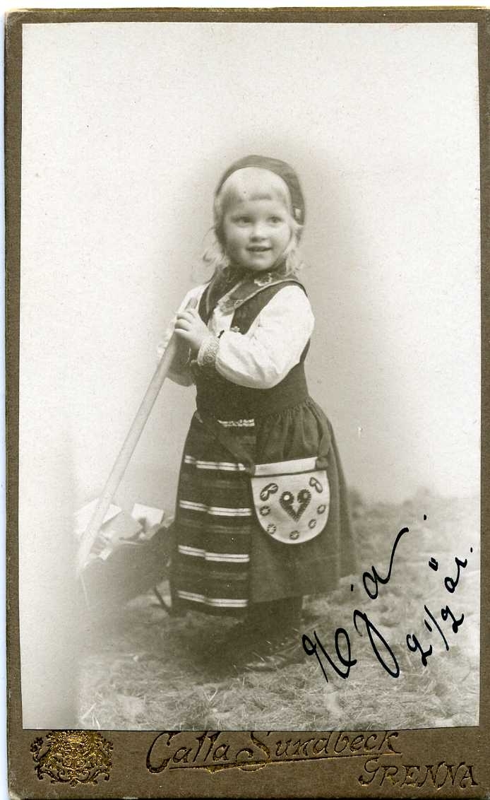 Porträtt av en liten flicka i folkdräkt.