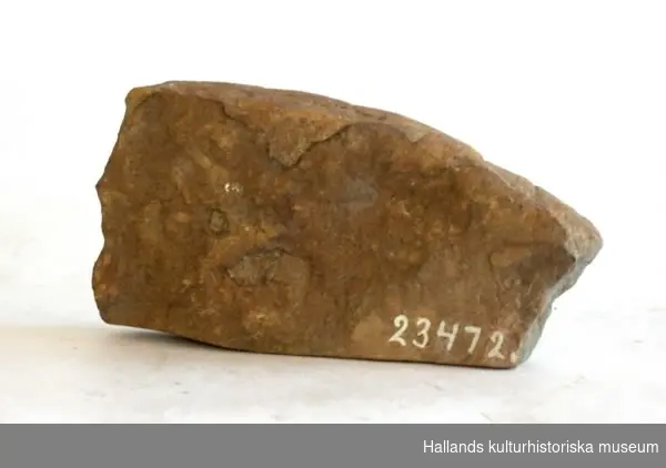 Arkeologiskt föremål. Brynsten, av sandsten. Fragment. Längd 10,5 cm. Bredd 5,5 cm (osäker uppgift mått).