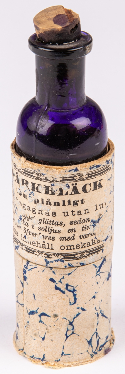 Flaska innehållande märkbläck, skrivbläck, violett. Etikett härstammande från Apoteket Lejonet, Gävle.