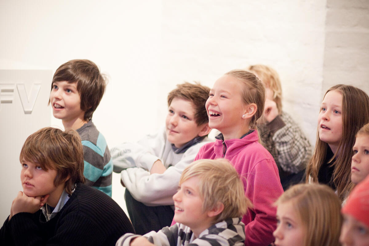 En gruppe med barn i utstillingen som ser glade ut.