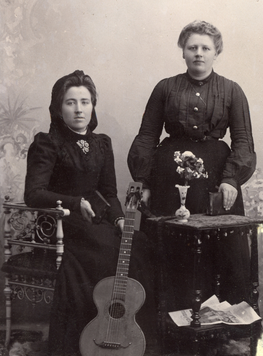To kvinner i fotoatelier med gitar