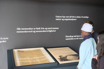 En gutt ser på en plakat av FNs menneskerettighetskonvensjon som ligger utstilf i et monter