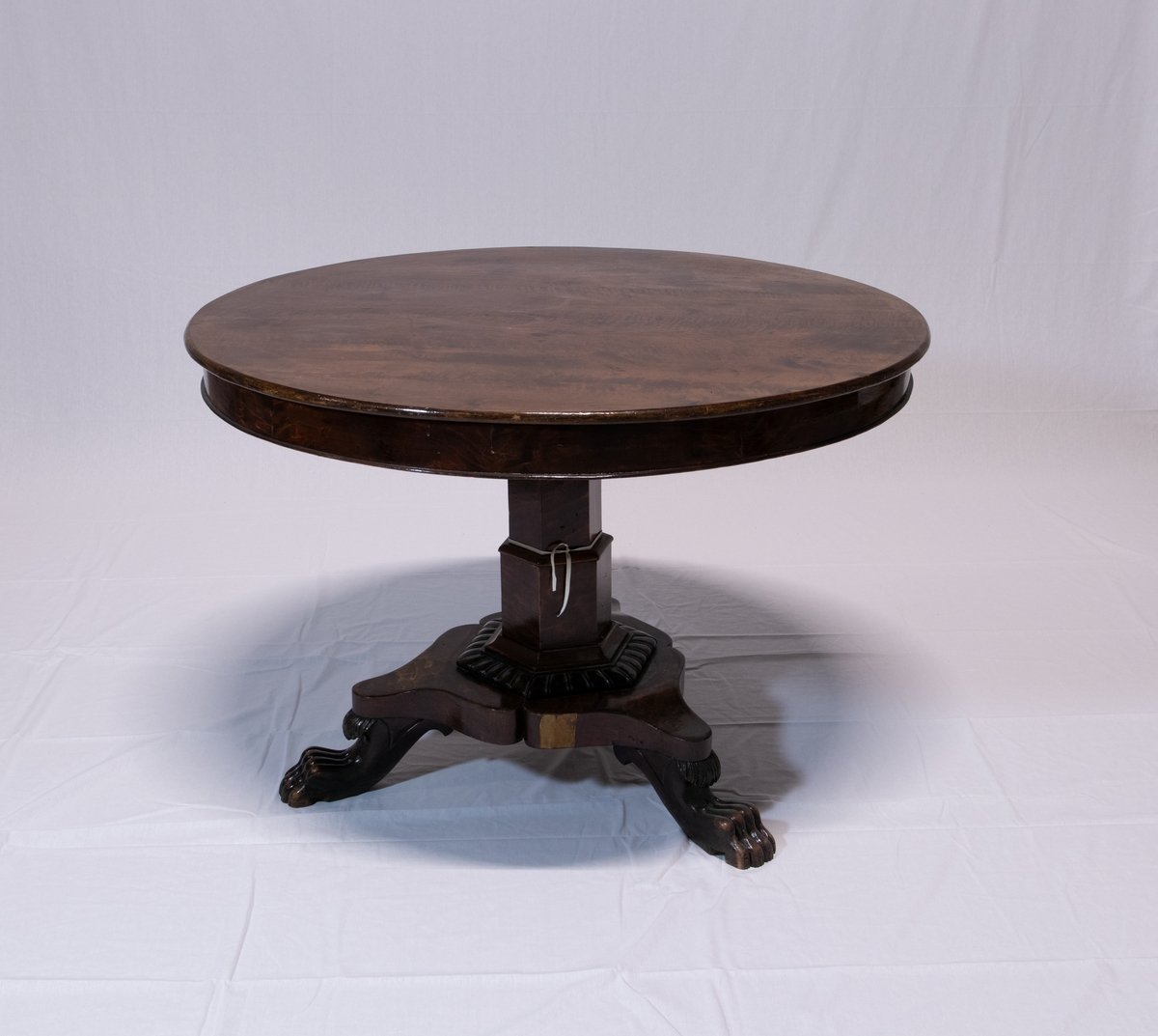 Stuemøblement av tre i fire deler. Bordet har rund bordflate med seks-kantet sokkel på tre løveføtter.