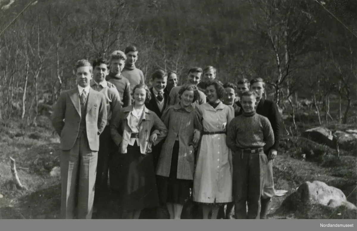 En gruppe unge mennesker fotografert utendørs. Tekst i album: Kl. 1 med klasseforstander 1938.