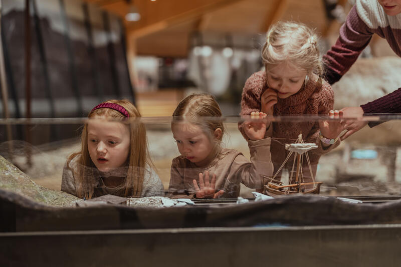 Bildet viser barn som studerer en av museets modeller. Modellen er om hvalvfangst.