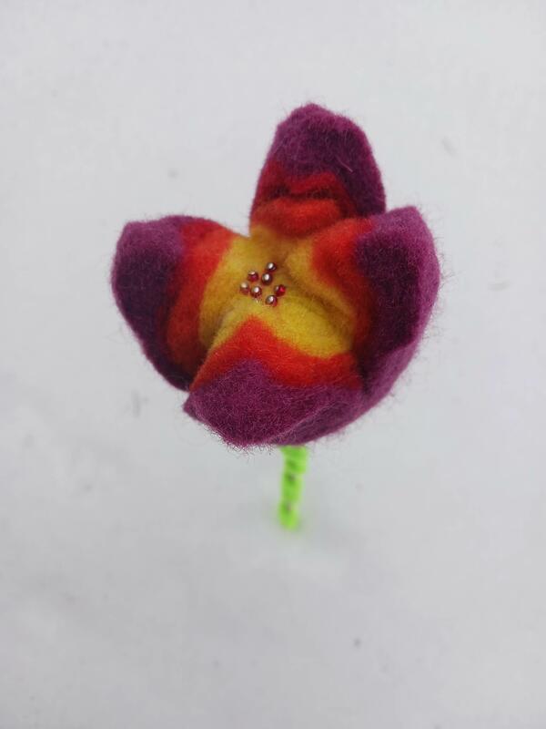 En blomst i tovet ull står i snø