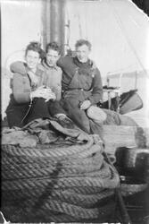 Amatørportrett av tre menn fra Grovfjord sittende på et båtd