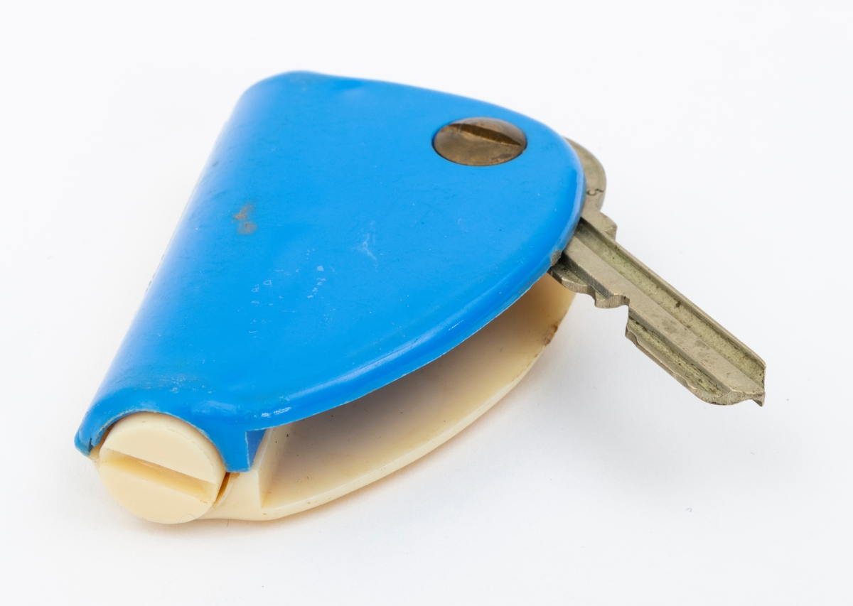 Nøkkel i blå og hvit plastholder med innebygd lommelykt.