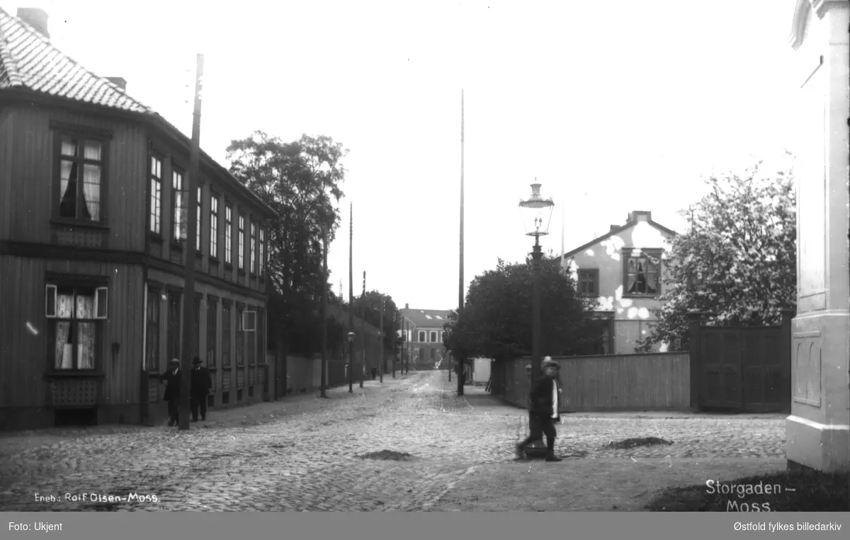 Stogata i Moss, krysset Storgata - Kirkegata ca. 1912. Gården til venstre er Reinertgården fra ca. 1860. Gården til høyre er Sangerhuset. 
Postkort.