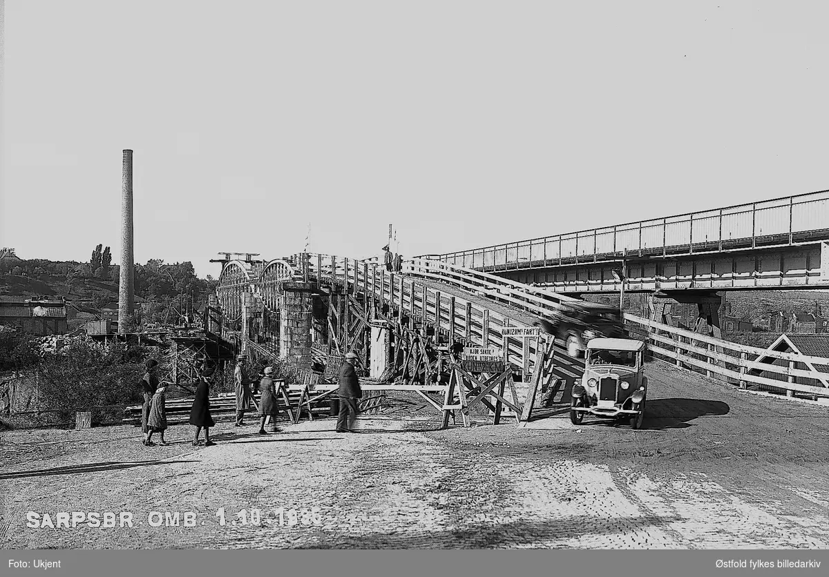 Sarpsbrua ombygd, 1. oktober 1936. 
Tekst på skilt: Kjør sakte, Broen utbedres, Kun 12 km,s fart.
Årstall uttydelig (1935 eller 1936)