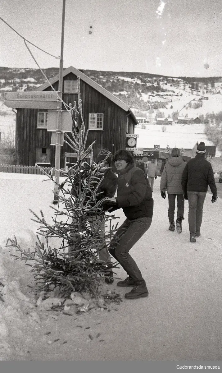 Prekeil'n, skuleavis Vågå ungdomsskule 1974-81
To bak juletre, Tord Stallvik til h. Bak: Flækøy Ur - Optikk og samvirkelaget.